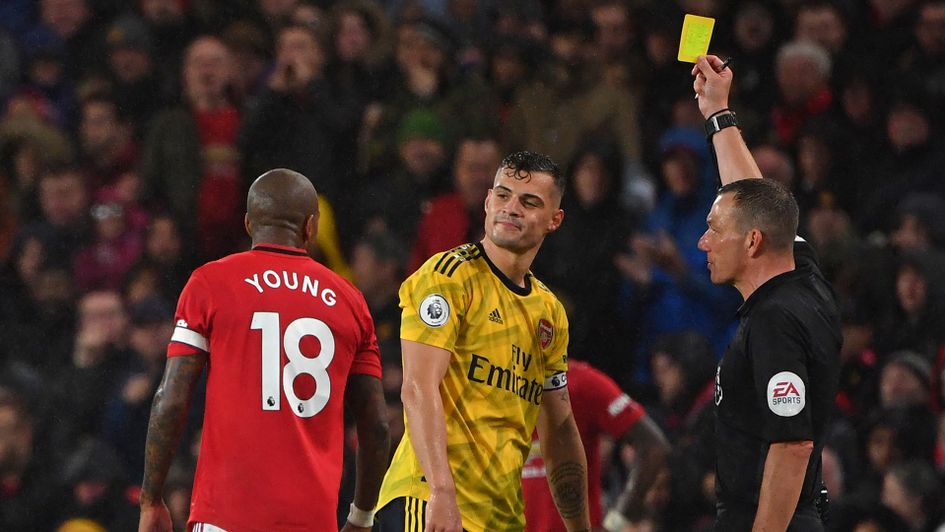 Granit Xhaka is booked by referee Kevin Friend