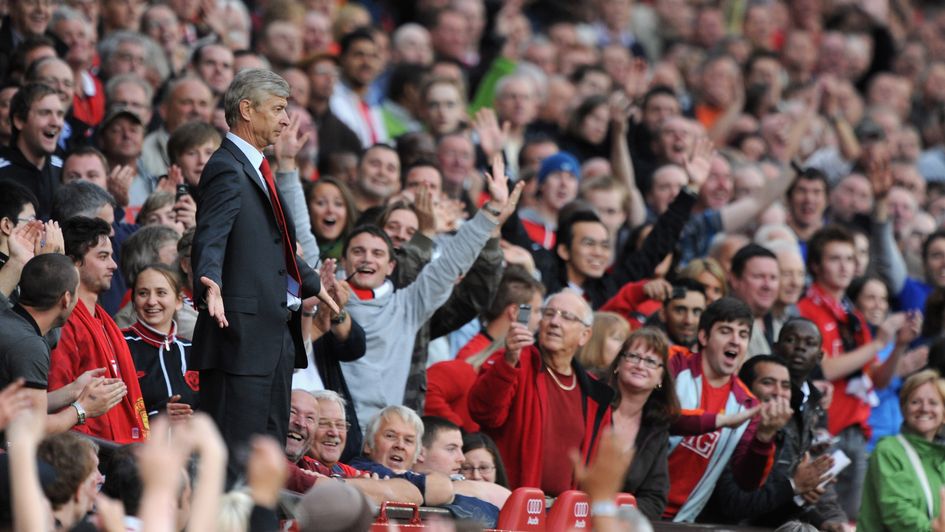 Wenger looks bewildered in the stands at Old Trafford, 2009