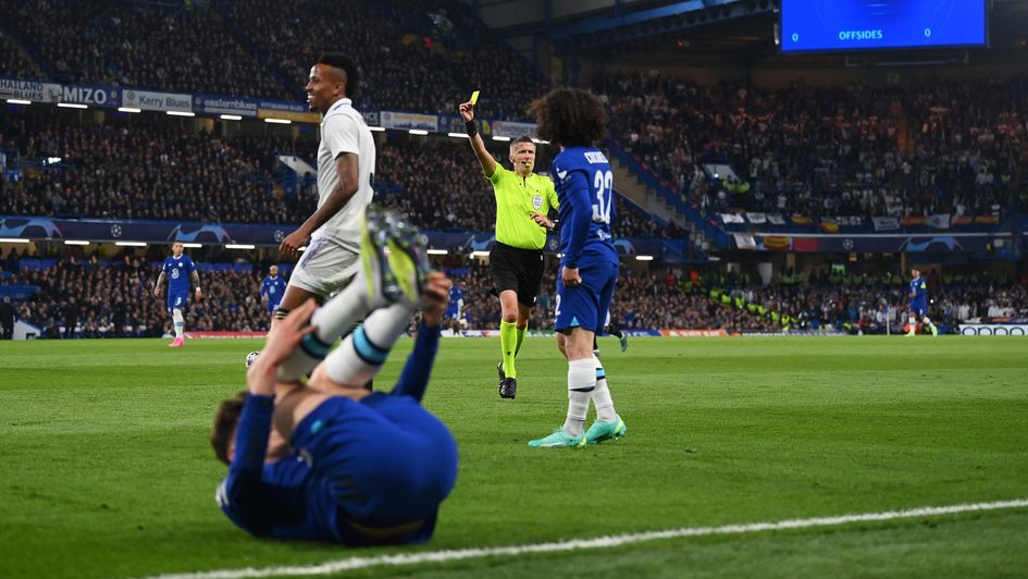 Eder Militao is shown a yellow card against Chelsea