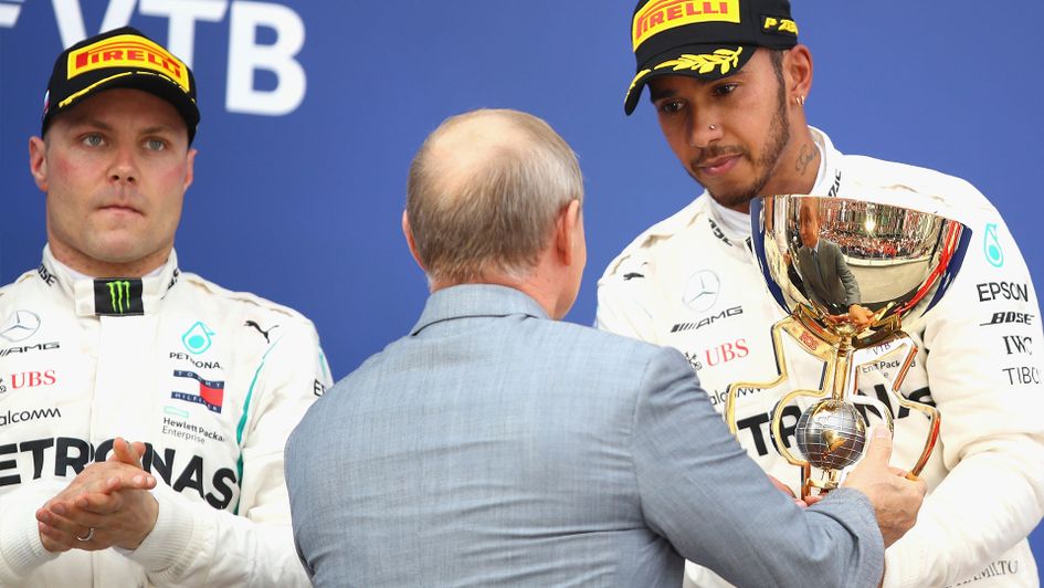 Valtteri Bottas (L), as Lewis Hamilton receives the victors trophy in Russia