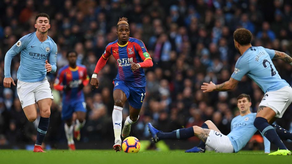 Wilfried Zaha takes on Manchester City's players at the Etihad