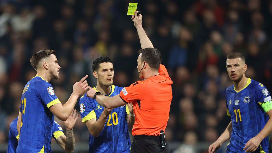 Referee Felix Zwayer shows the yellow card to Bosnia's Jusuf Gazibegovic