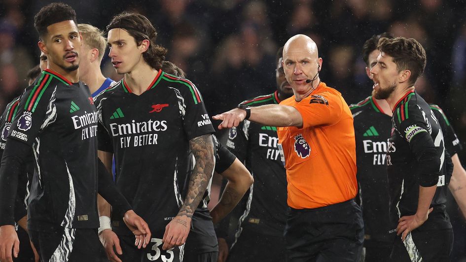 Arsenal players surround referee Anthony Taylor