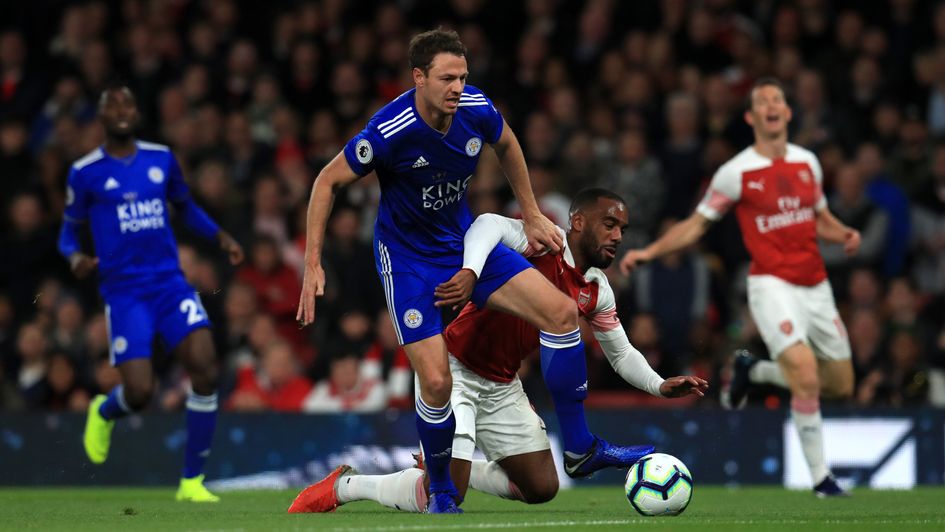 Arsenal's Alexandre Lacazette is challenged by Leicester City's Jonny Evans