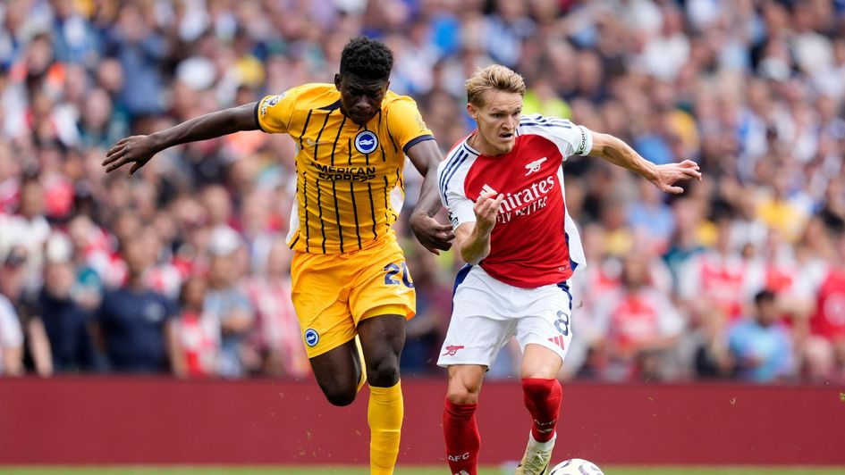 Carlos Baleba tussling with Martin Odegaard