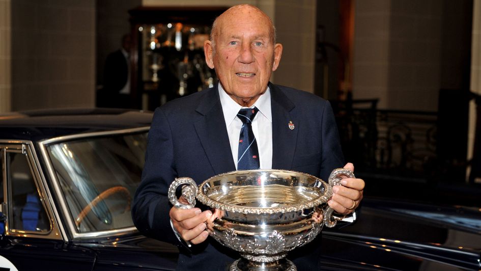 Sir Stirling Moss, holds the British GP winners trophy which he won in 1955